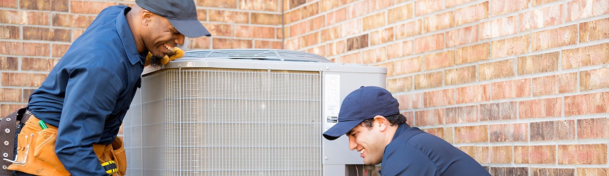 two-repair-men-working-on-hvac-unit